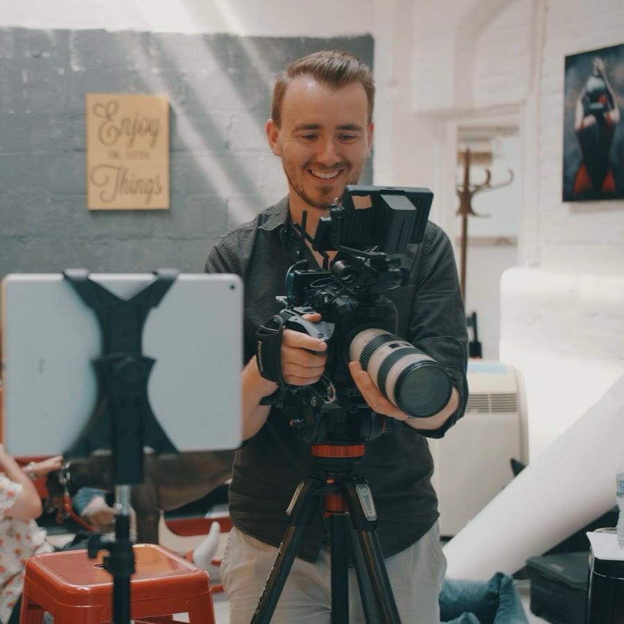 Director of video production agency Nomadic UK using a video camera with a white lens in a studio