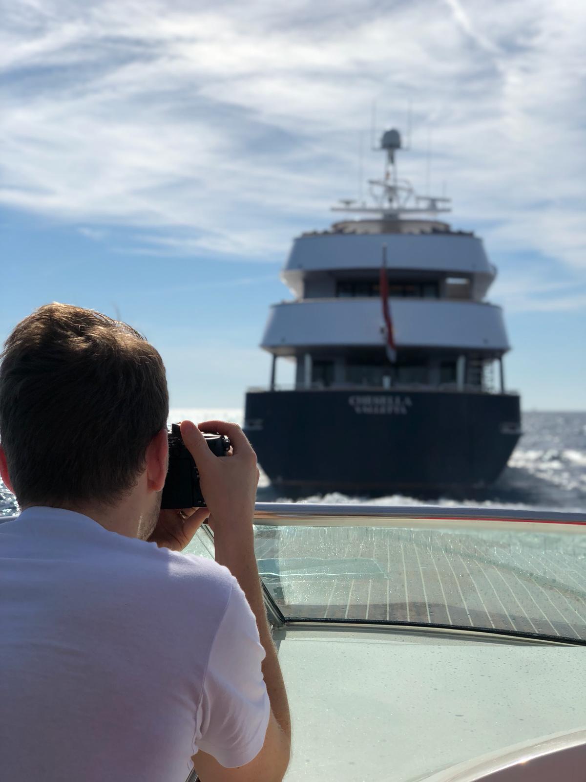 Photographer on a tender capturing shots of a private yacht called Chesella. By Nomadic UK